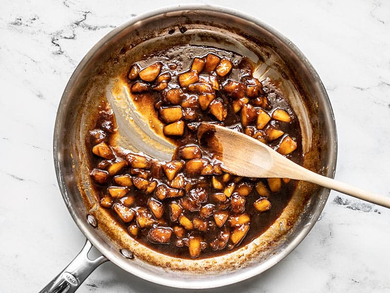 Reduced Balsamic Peaches in the Skillet with a spoon dragged through to show thickness