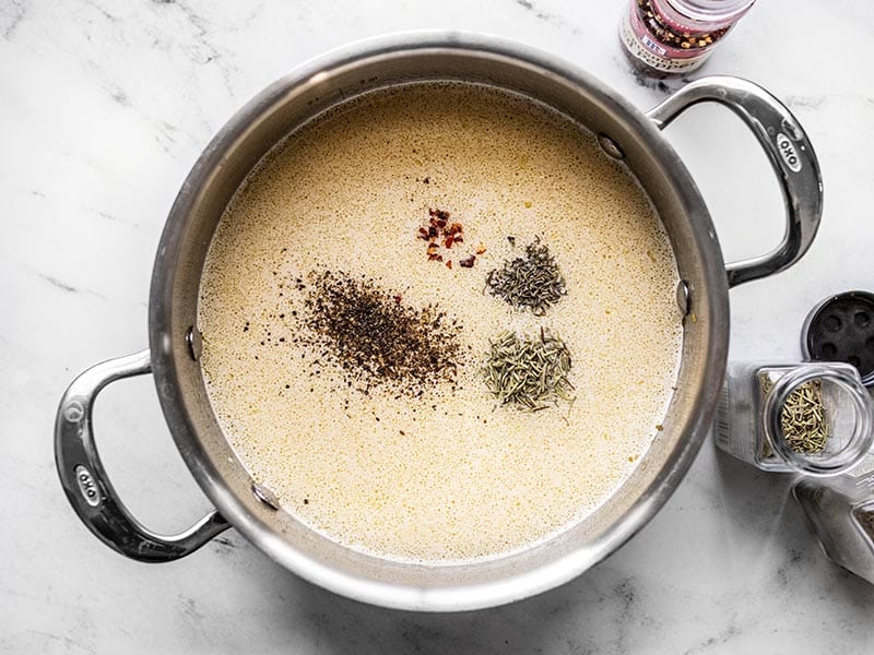 Broth and herbs added to the soup.