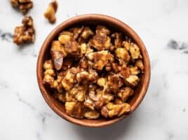 Overhead view of a bowl full of candied walnuts