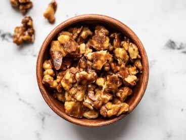 Overhead view of a bowl full of candied walnuts