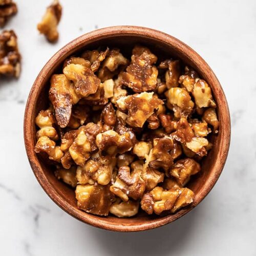 Overhead view of a bowl full of candied walnuts