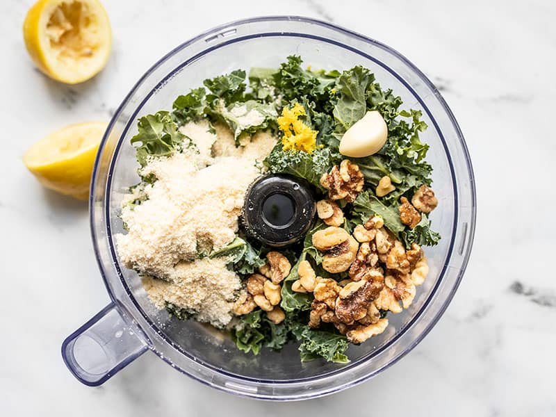 Kale pesto ingredients in the food processor, whole.