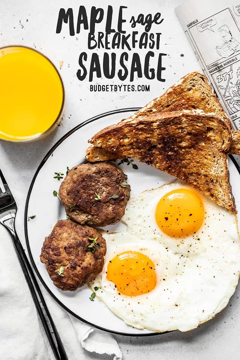 A breakfast plate with eggs, toast, and maple sage breakfast sausage next to a glass of orange juice.