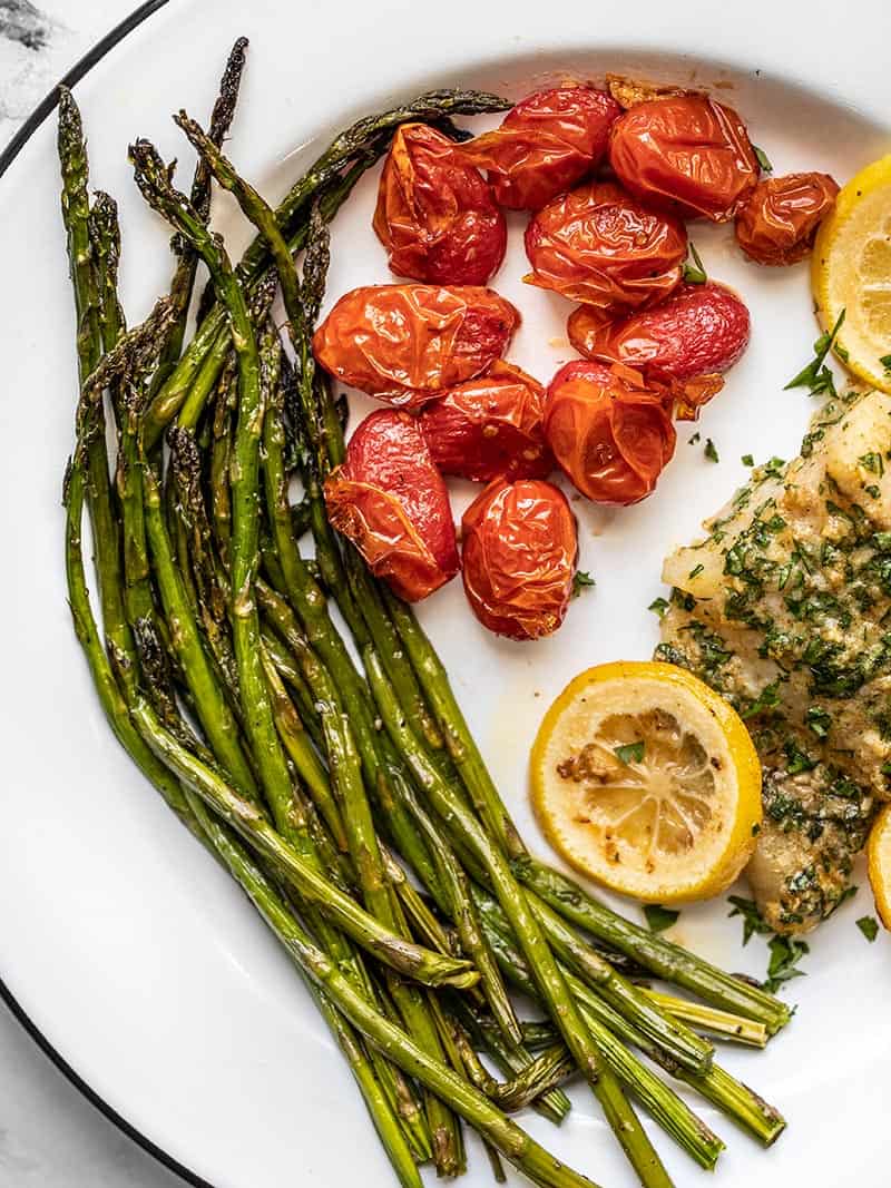 Close up of Roasted Asparagus and Tomatoes on a dinner plate.