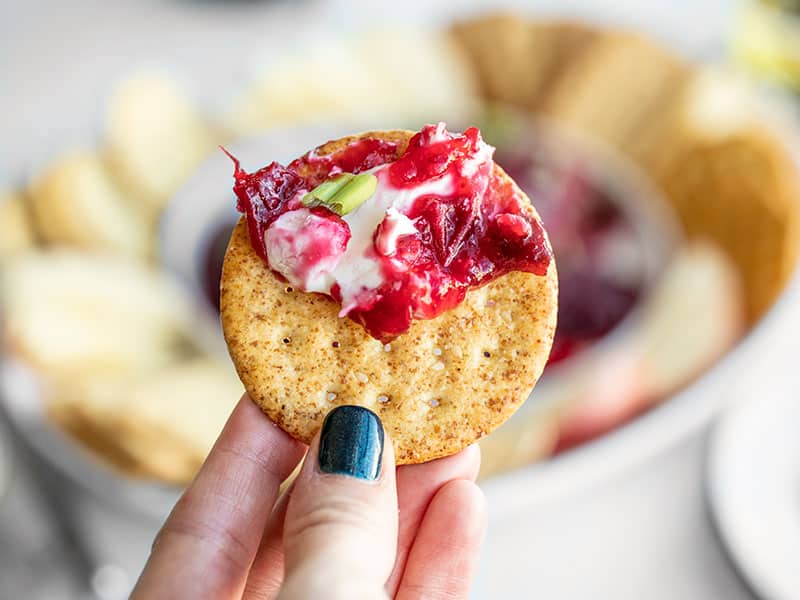 Close up of cranberry cream cheese dip smeared on a cracker