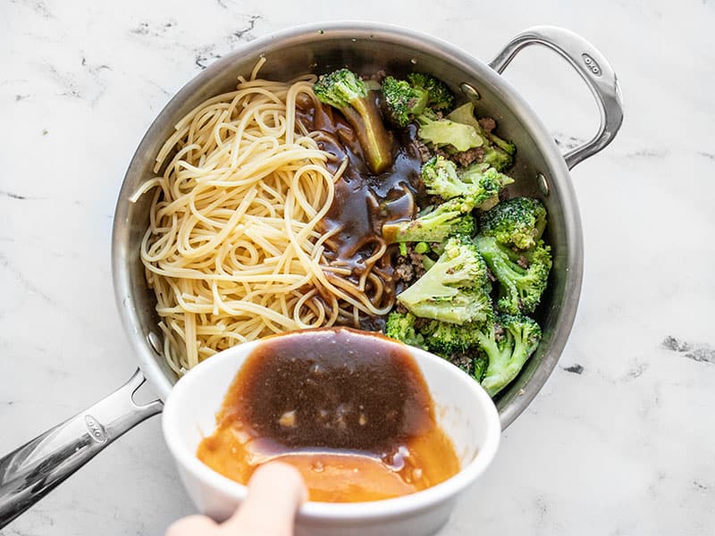 Spaghetti and sauce added to the skillet with beef and broccoli