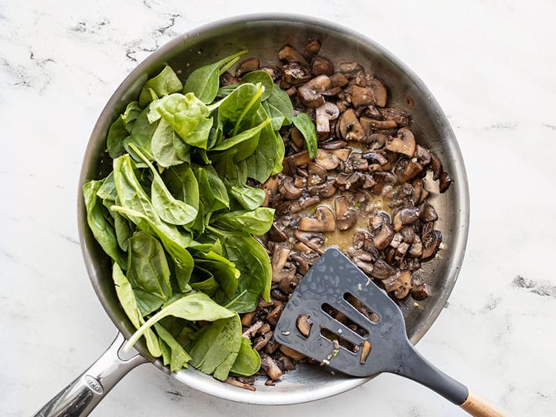 Add spinach and starchy water to skillet