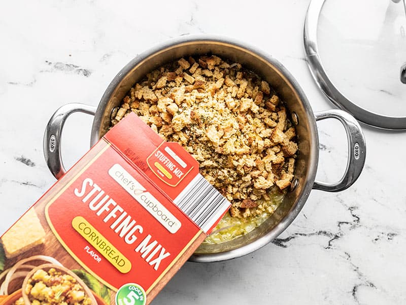 Cornbread stuffing mix being poured into the pot of boiling water