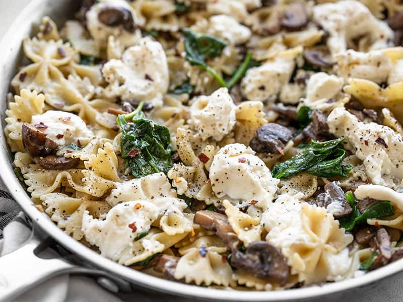 Close up of Mushroom and Spinach Pasta with Ricotta in the skillet, from the side.