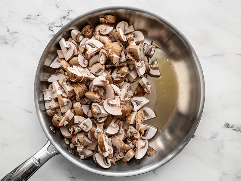 Sliced mushrooms and olive oil in a large skillet