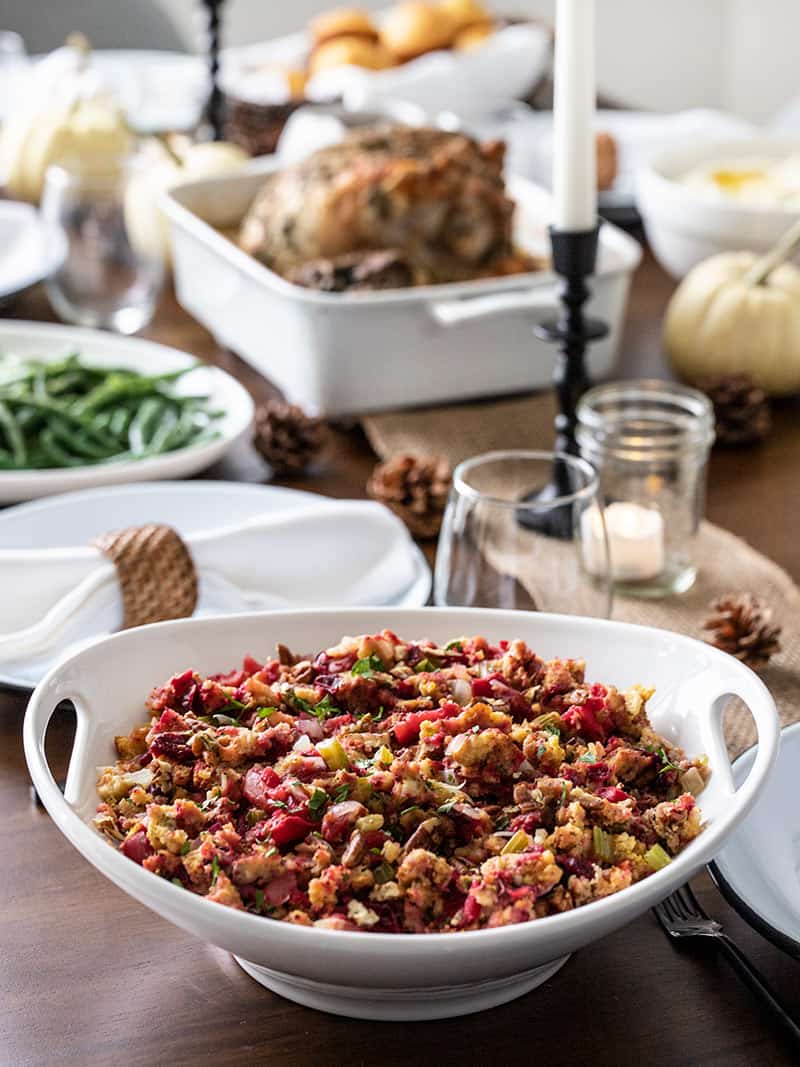 Roasted Apple Cranberry Cornbread Stuffing on a Thanksgiving table with other dishes in the background