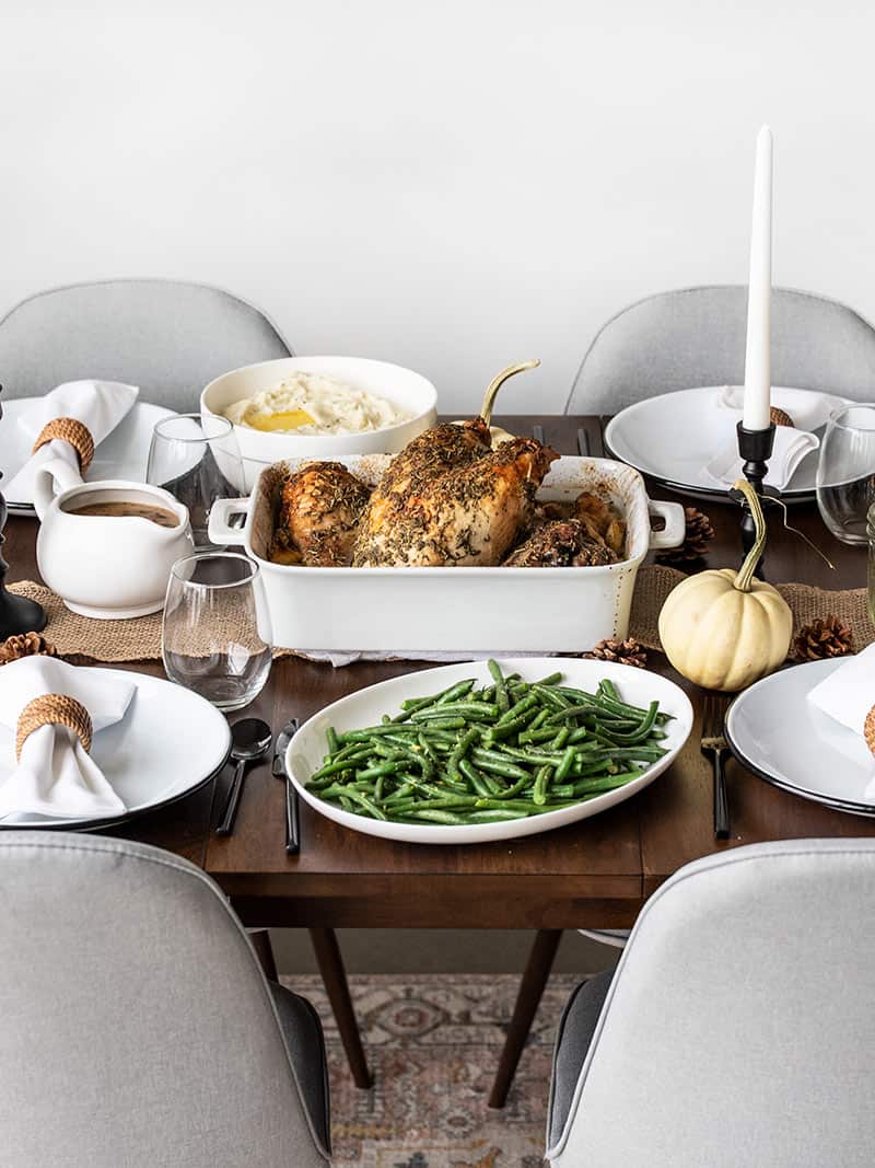 Side view of a simple Thanksgiving dinner table with turkey, green beans, and mashed potatoes