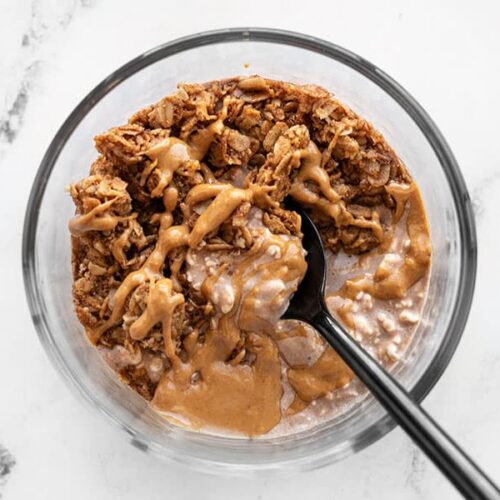 Chocolate flavored cottage cheese with peanut butter and granola in a glass bowl