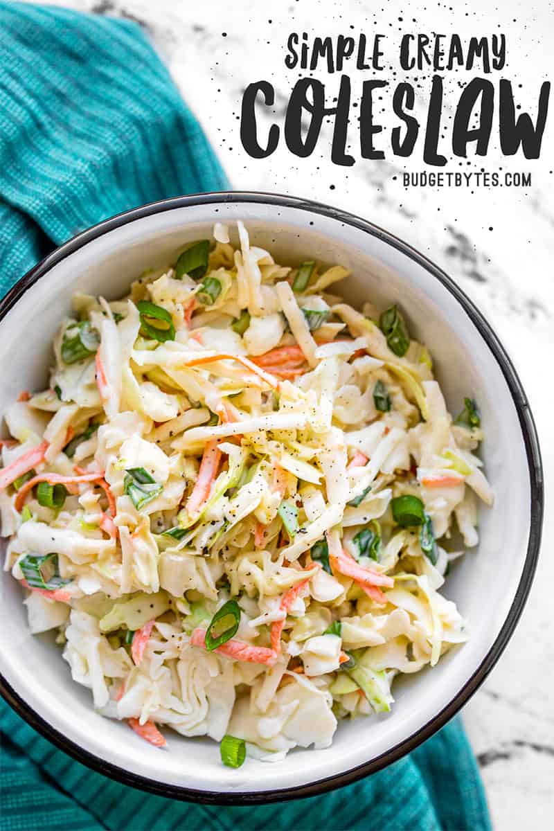 Overhead view of a bowl full of creamy coleslaw on a blue napkin