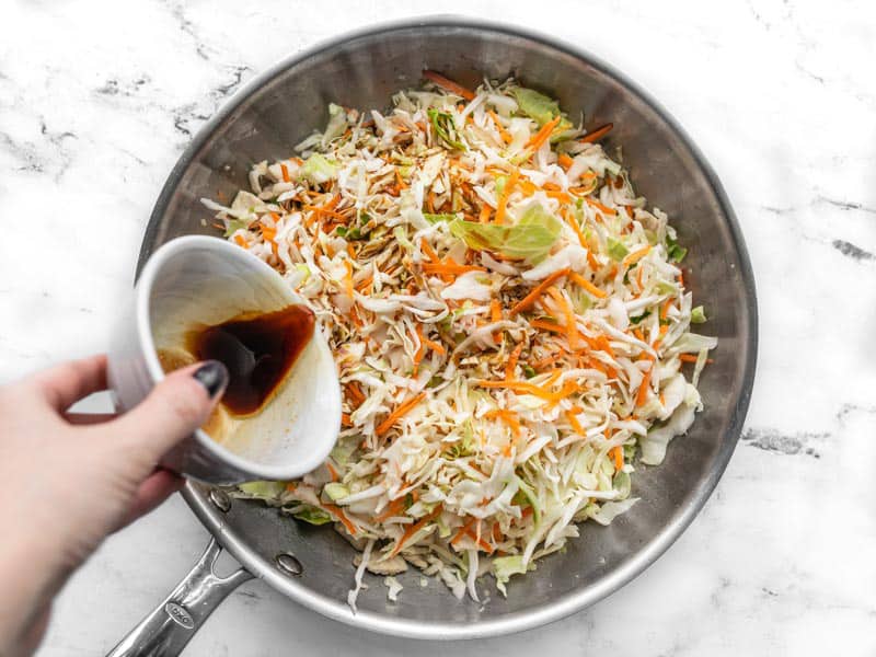 Stir fry sauce being poured into the skillet