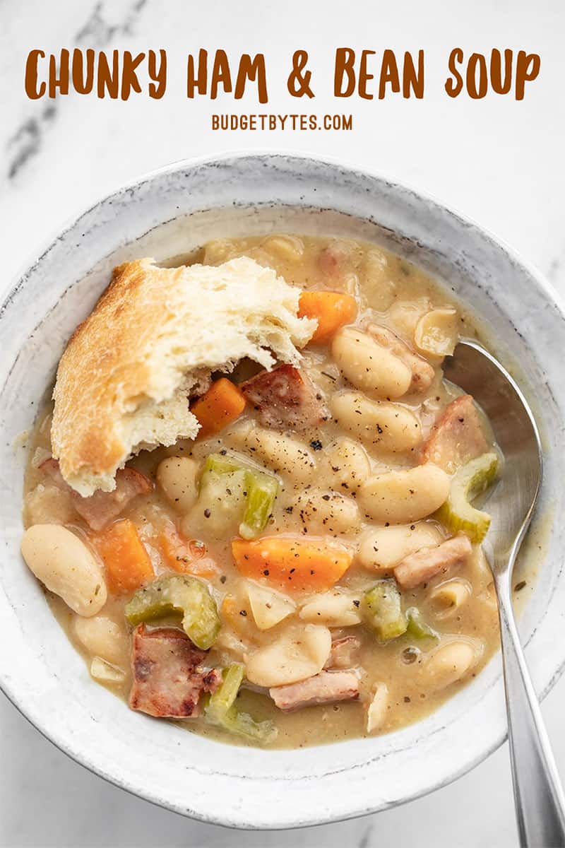 Close up overhead view of one bowl of chunky ham and bean soup with title text at the top