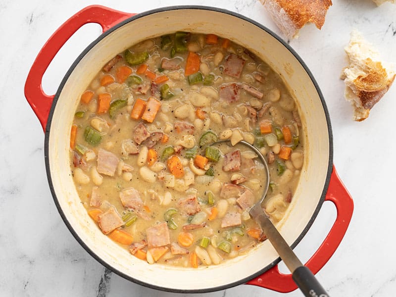 Finished chunky ham and bean soup in the soup pot with bread on the side