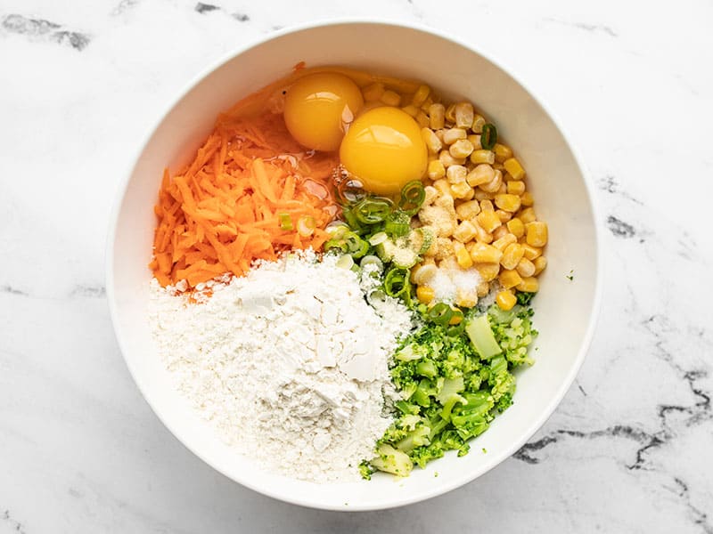 Vegetables in the bowl with flour, eggs, and seasoning.