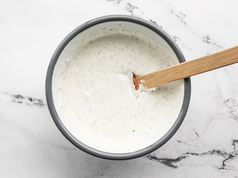 A small bowl with garlic herb dipping sauce and a small spatula