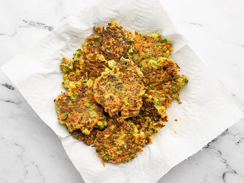 Cooked vegetable fritters on a paper towel lined plate