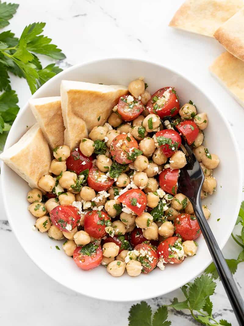 Overhead view of Chimichurri Chickpea Salad with triangles of pita bread stuck in the side.