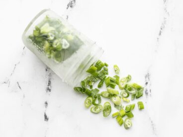 Frozen sliced green onion pouring out of a mason jar