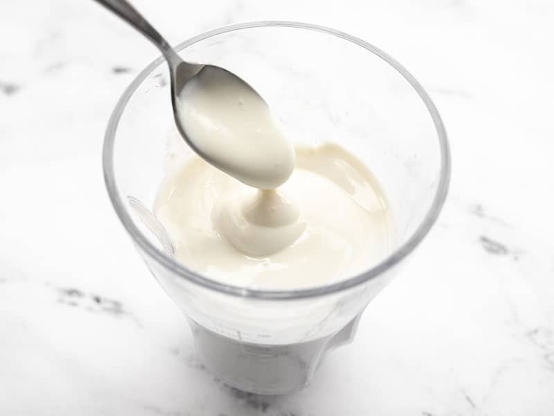 A spoon lifting the blended fruit dip from the blender