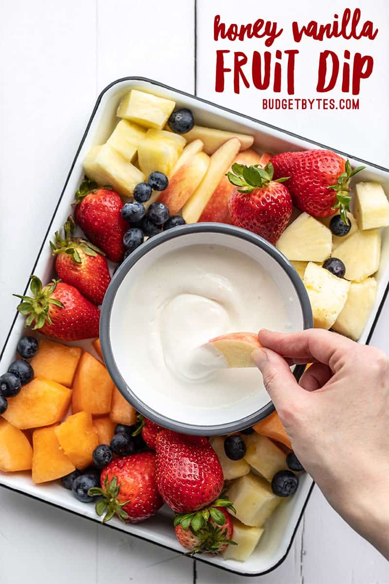 A piece of apple being dipped into the cottage cheese fruit dip