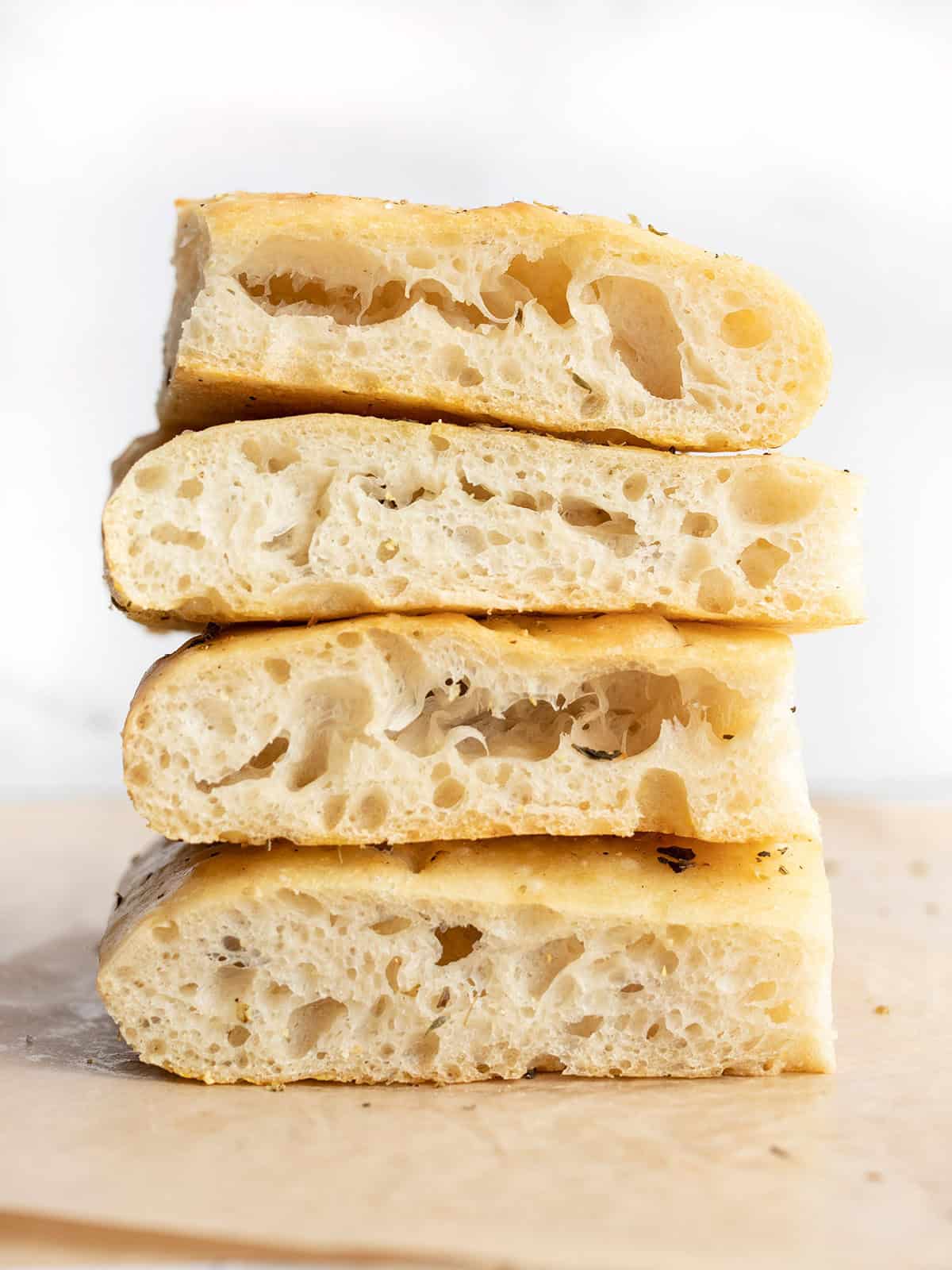 A stack of no knead focaccia bread slices showing off the internal bubbles.