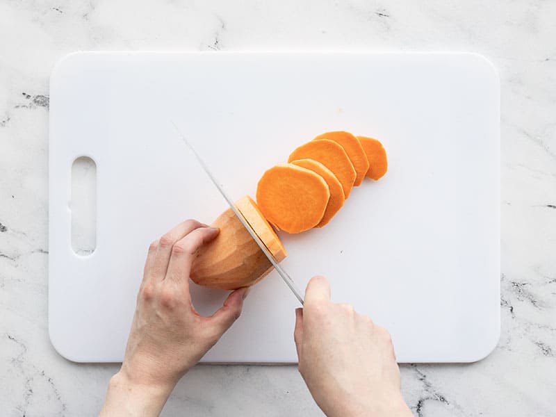 Sweet potato being cut into rounds