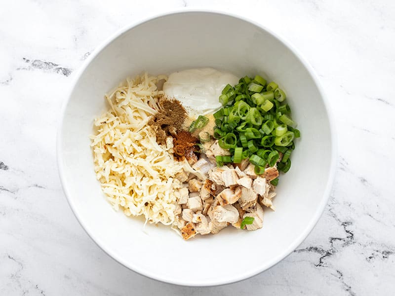 chicken enchilada filling ingredients in a bowl, not mixed.