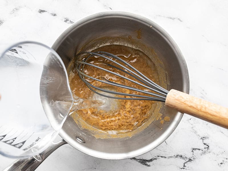 Water being poured into the sauce pot