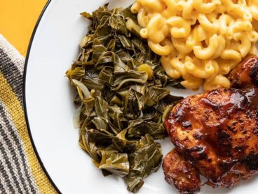 jerk seasoned collard greens on a plate with mac and cheese and bbq chicken