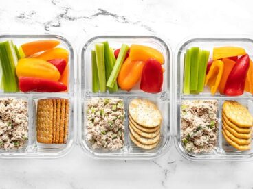 Three glass containers full of the tuna salad lunch box lined up in a row