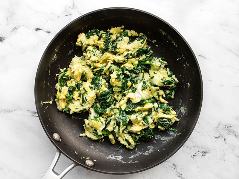 Eggs folded with spinach in the skillet