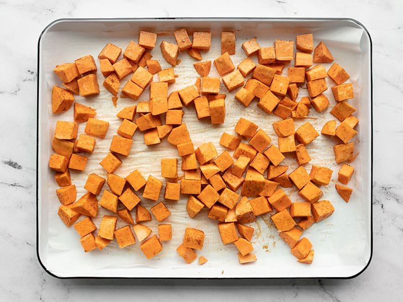 Sweet potatoes prepped for roasting on a sheet pan