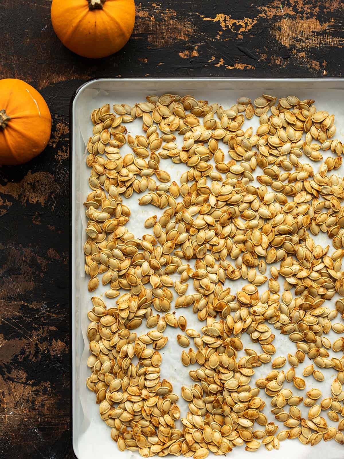 Overhead view of a sheet pan full of roasted pumpkin seeds.