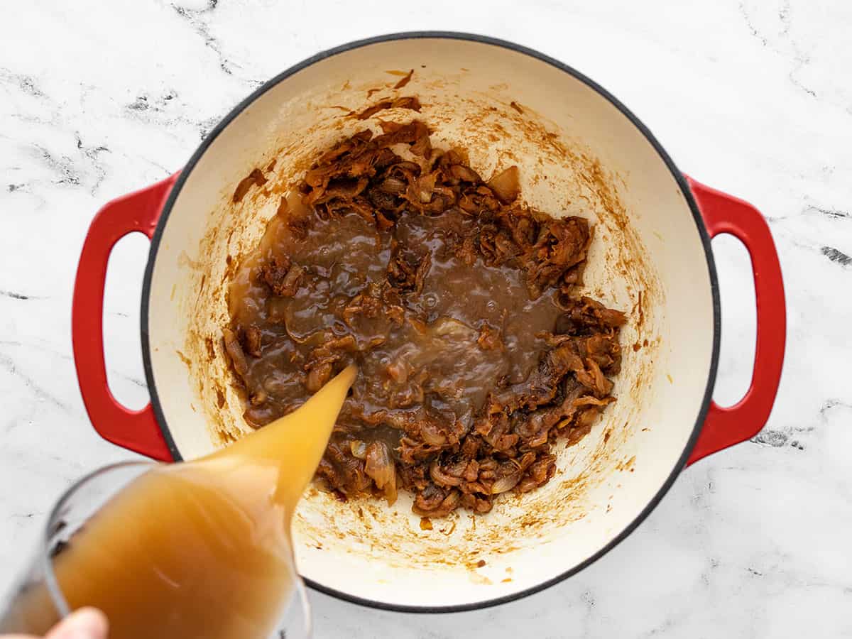 Beef broth being added to the pot