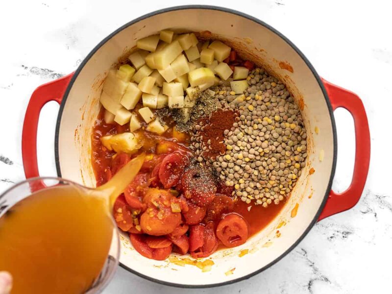 Potatoes, lentils, tomatoes, seasoning, and broth added to the pot