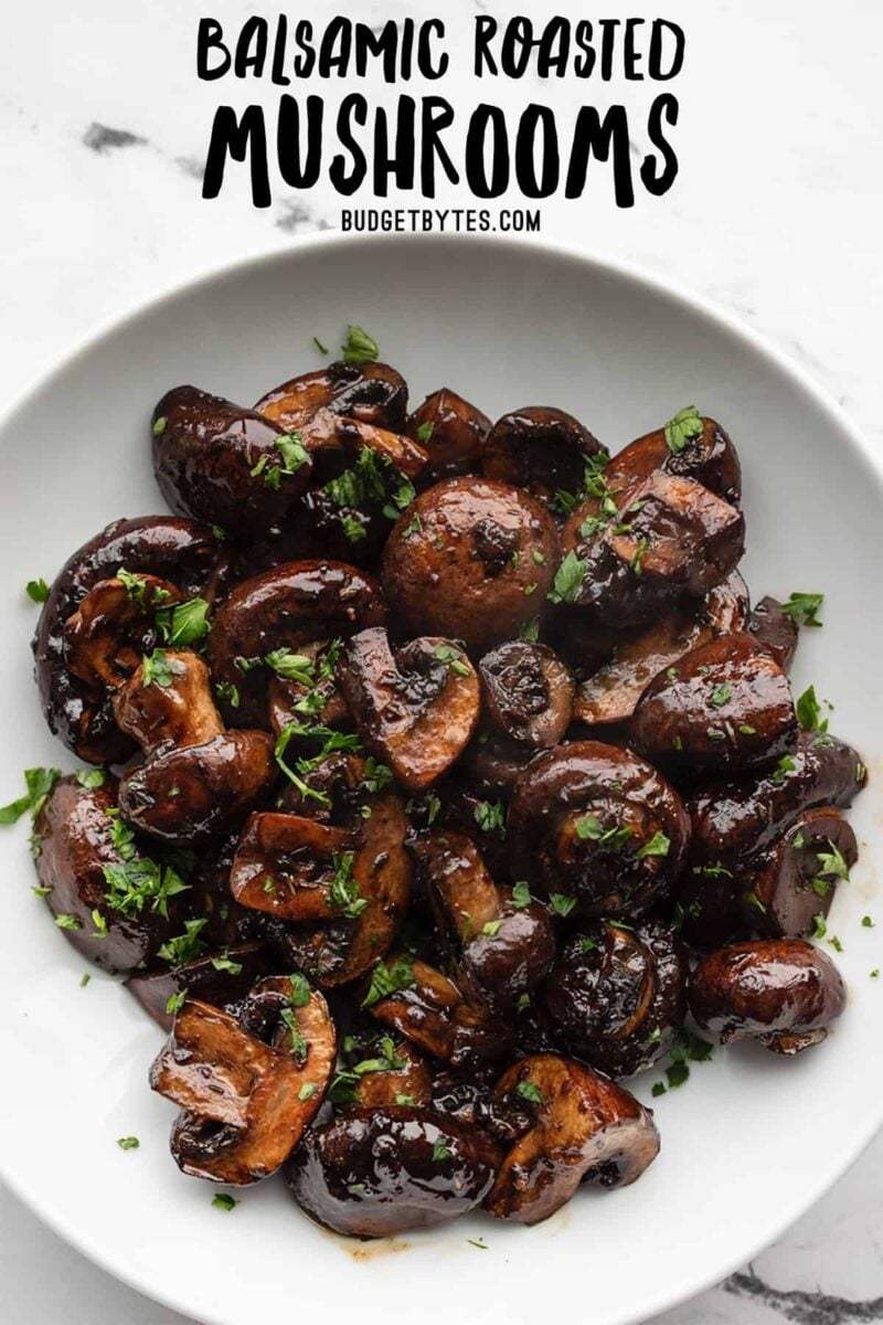 Overhead view of a bowl full of balsamic roasted mushrooms with title text at the top