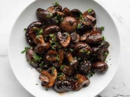 Overhead view of balsamic roasted mushrooms in a white bowl