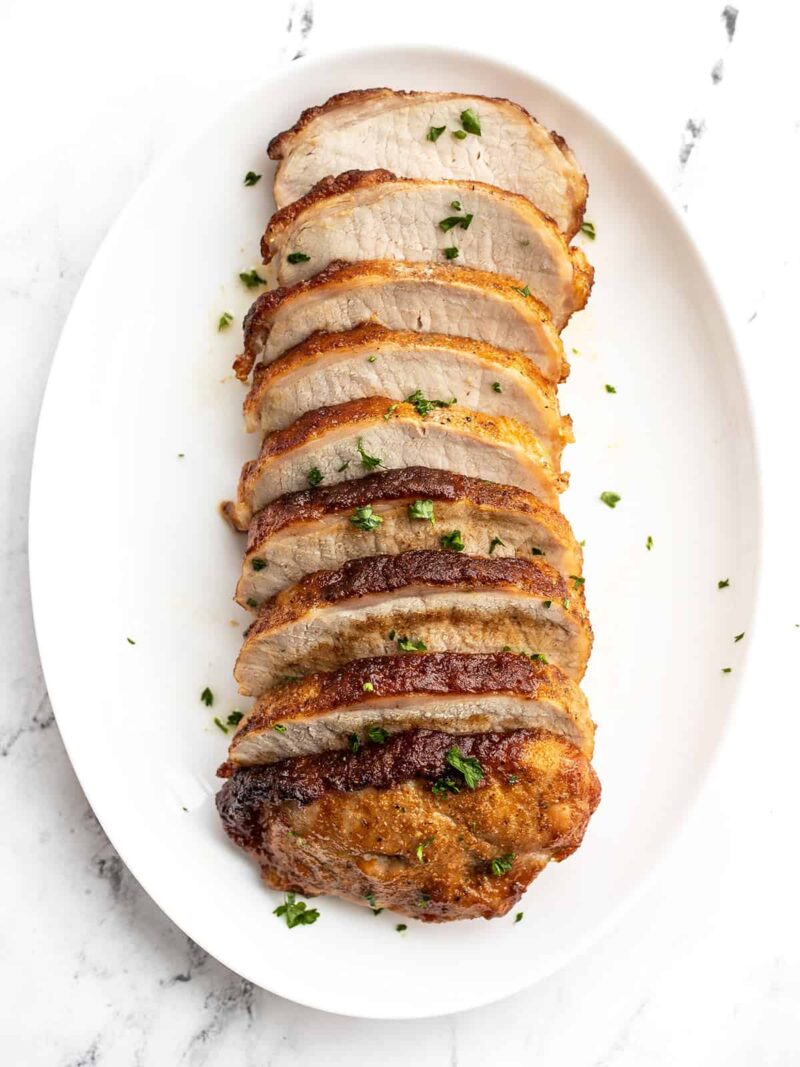 Brown sugar roasted pork loin sliced and served on an oval dish