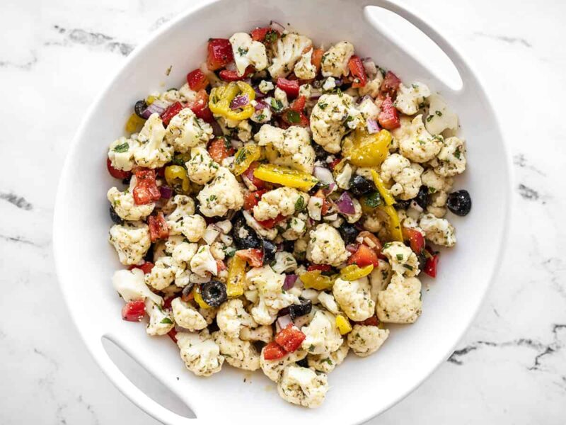 Overhead view of marinated cauliflower salad in a white serving bowl