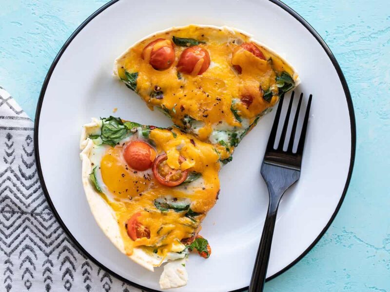 Two slices of tortilla baked eggs on a plate with a fork