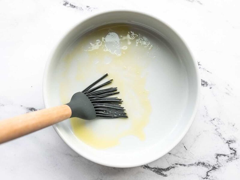 Oil being brushed inside a round dish