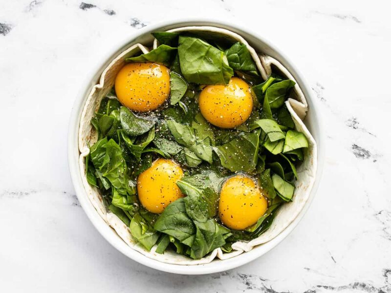 Eggs added on top of the spinach in the tortilla