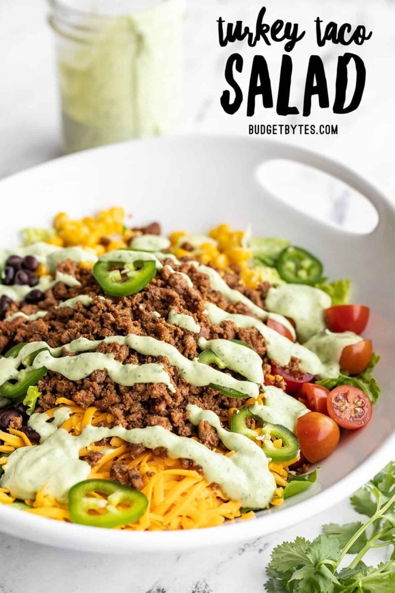 Side view of turkey taco salad in a serving bowl, title text at the top