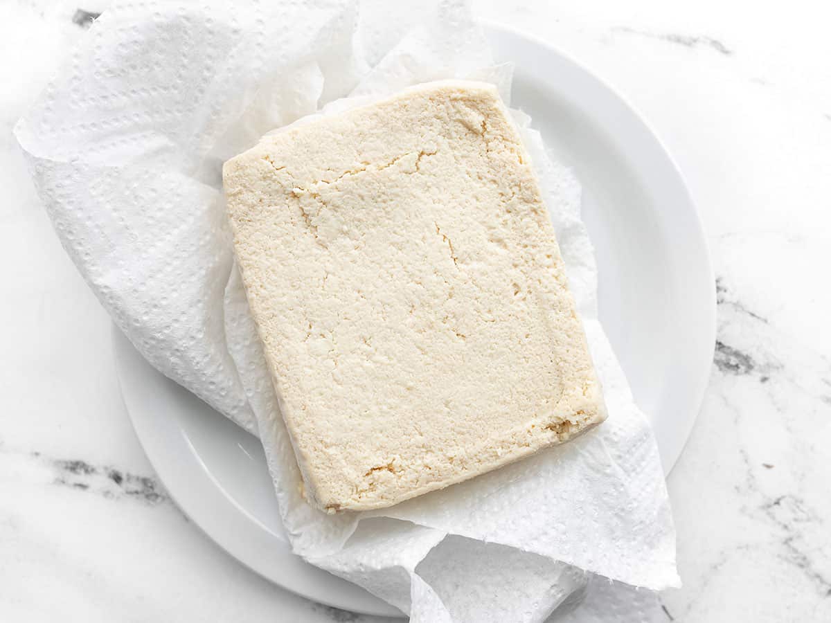 Pressed tofu on a plate with paper towel