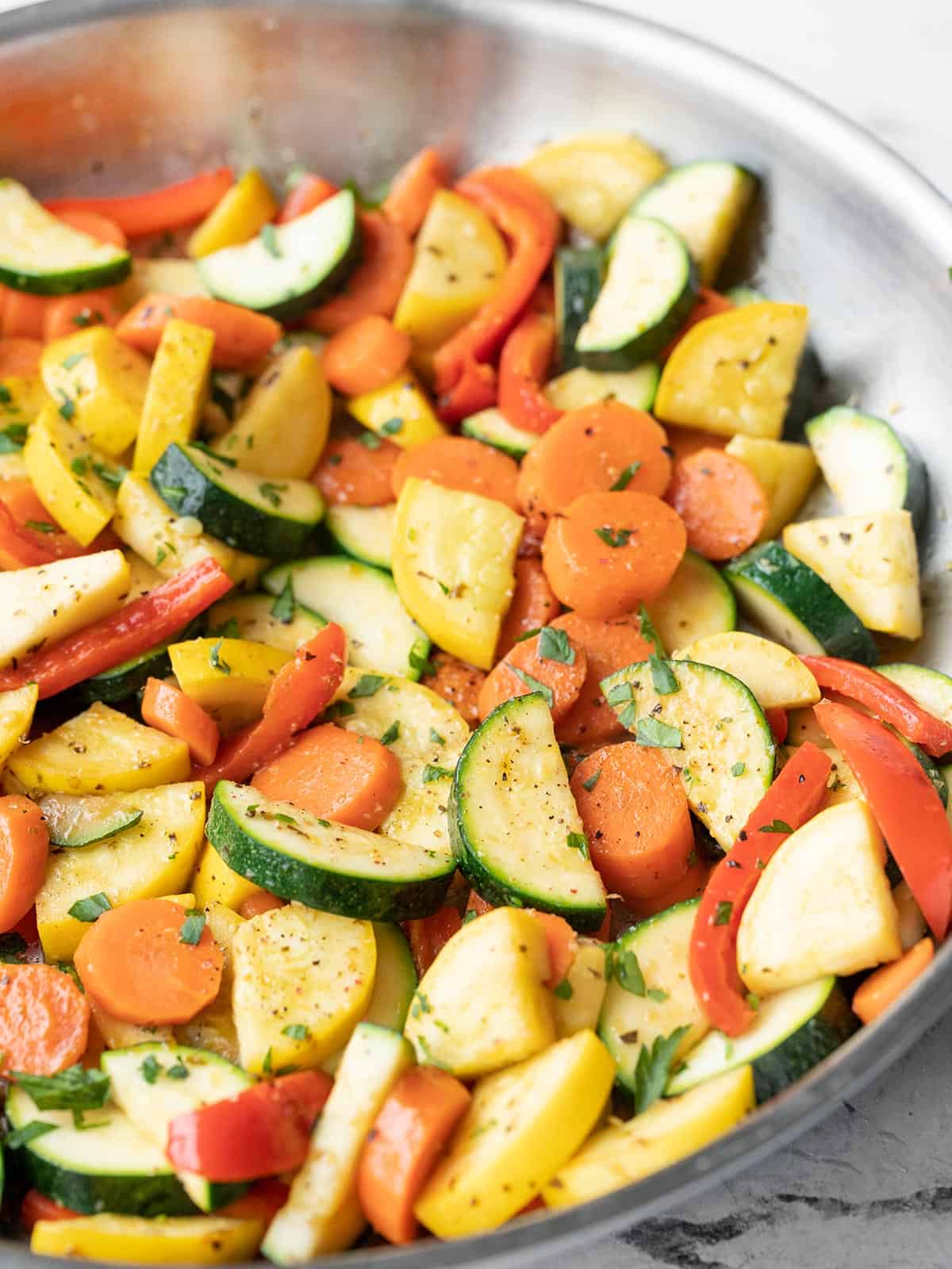 Close up side view of sautéed vegetables in the skillet