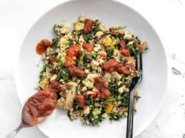 Salsa being spooned onto a bowl of Vegetable Tofu Scramble